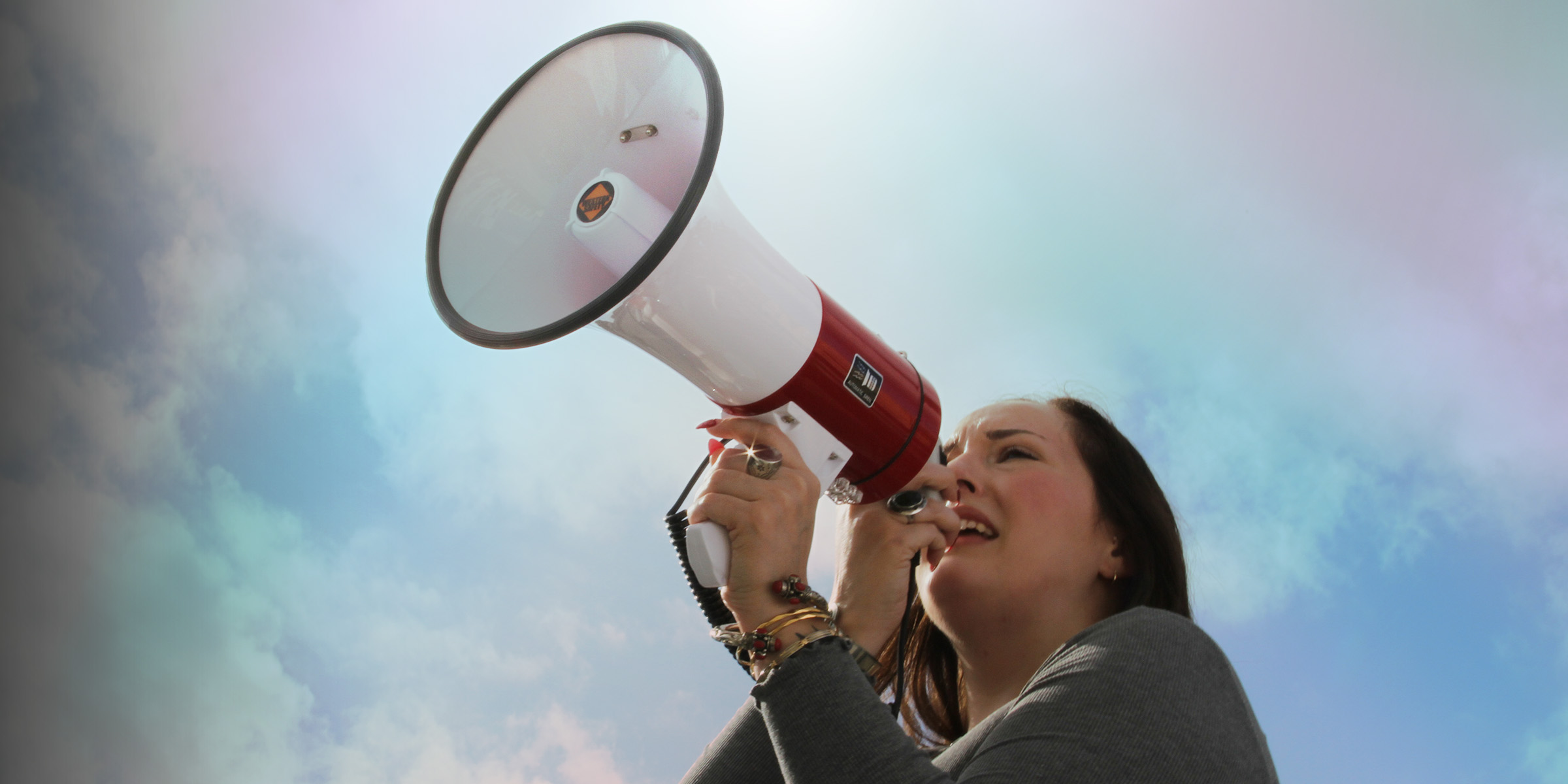 A woman passionately speaks into a megaphone.