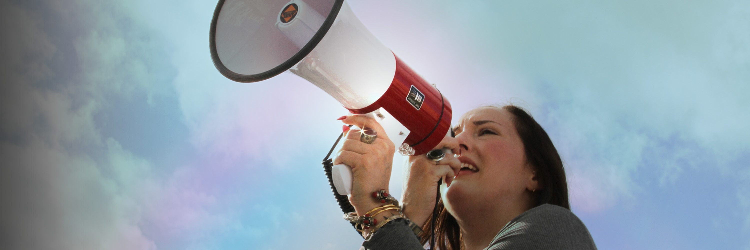 A woman passionately speaks into a megaphone.